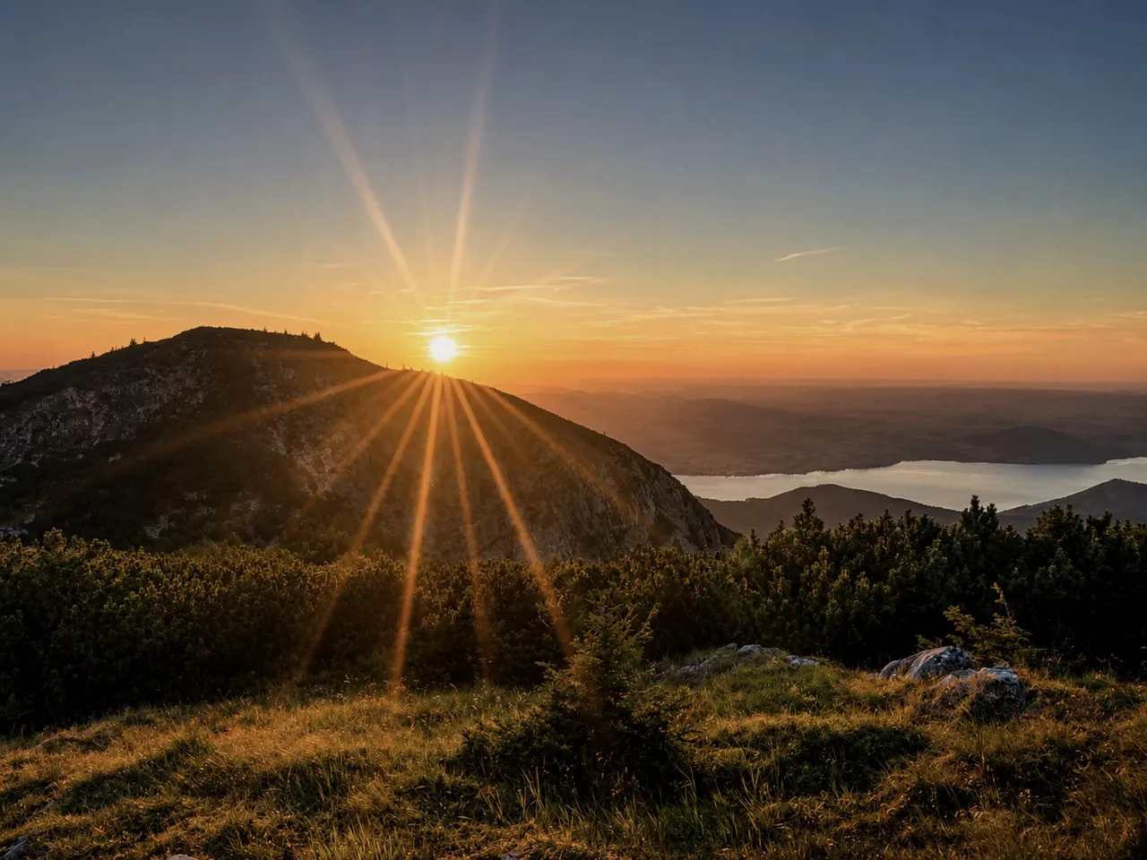 Sonnenaufgang über dem Grat, der See in der Ferne